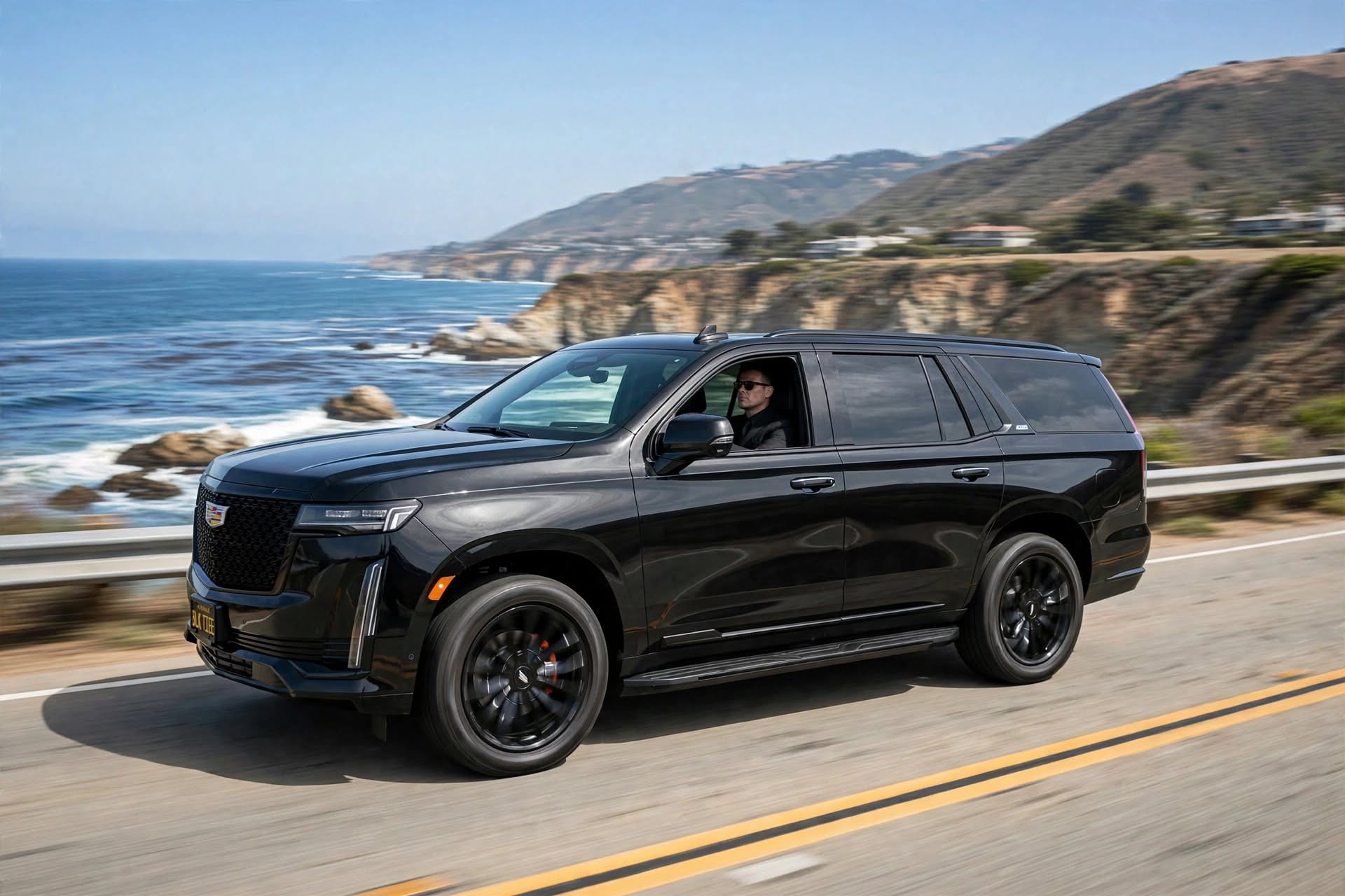 A black Cadillac Escalade traveling along the Southern California coast